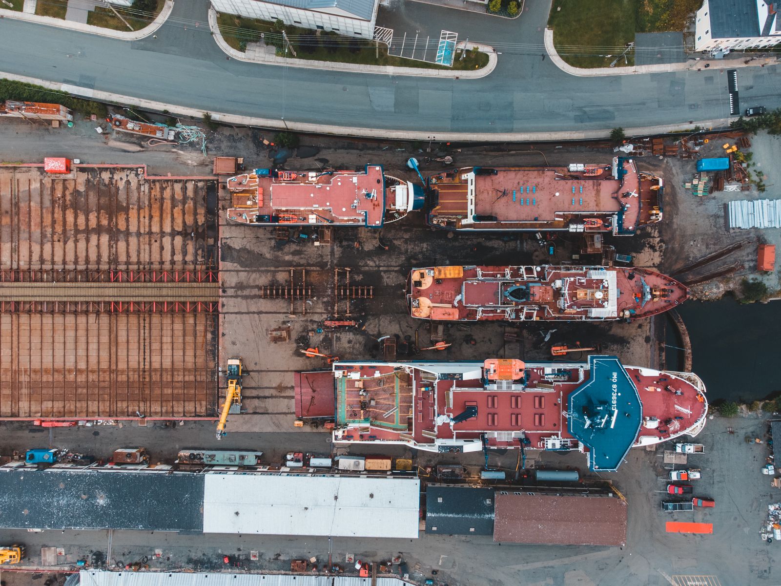 Aerial view of a shipyard with vessels in dry dock and heavy machinery